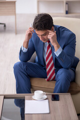 Young male employee sitting in the office