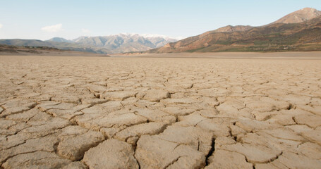 shot of cracked soil ground of dried lake or river in mountains. Land destroyed by erosion and...