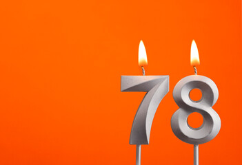 Number 78 - Silver Anniversary candle on orange background