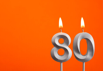 Number 80 - Silver Anniversary candle on orange background
