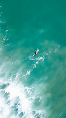 Aerial photography in Costa Rica, surfer alone int the ocean with big waves and amazing colors