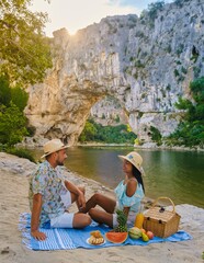 couple having picnic on the beach on vacation in the Ardeche France Pont d Arc, Ardeche France,...