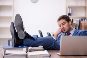 Young male employee unhappy with excessive work in the office