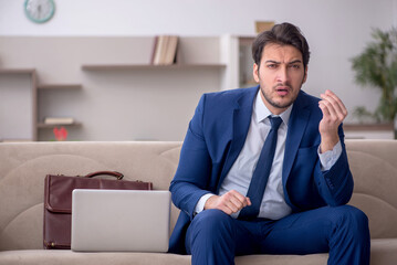 Fototapeta premium Young male employee working from home during pandemic