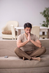 Fototapeta premium Young man sitting at home during pandemic