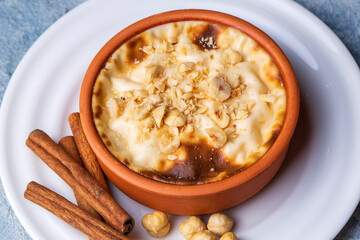 Baked rice pudding turkish milky dessert sutlac in earthenware casserole with hazelnuts