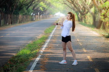 Young woman runner running on garden road,woman fitness silhouette sunrise jogging workout wellness concept.