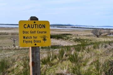 Caution, watch for flying disks sign.