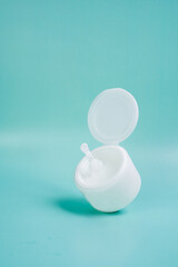 Face cream in a white jar on a blue background. Closeup