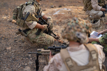 Fototapeta premium Team of U.S. Army marine corps soldier military war with gun weapon participating and preparing to attack the enemy in Thailand during exercise Cobra Gold training in battle. Combat force.