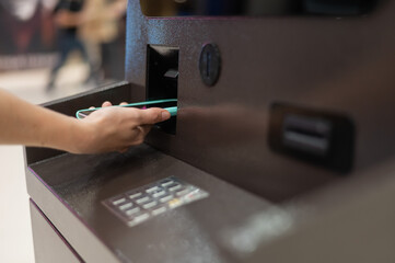 Woman using smartphone online financial transactions at ATM. NFC online banking concept. 