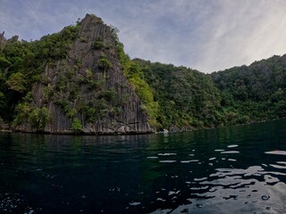 Fototapeta na wymiar Majestic rocks in Coron, Palawan in the Philippines that are overgrown with shrubs and rise out of the water.