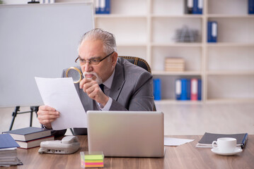 Old male employee working in the office