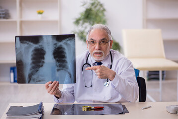 Old male doctor radiologist working in the clinic