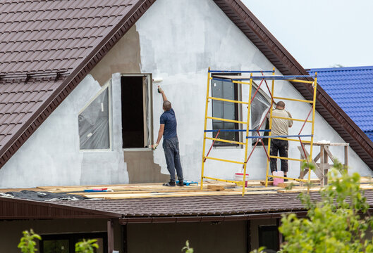 Workers are priming outside the walls of the house.