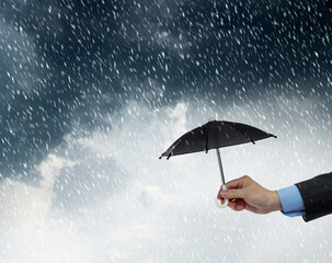 Businessman holding a umbrella in rainy day