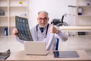 Old male doctor radiologist working in the clinic