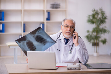 Old male doctor radiologist working in the clinic
