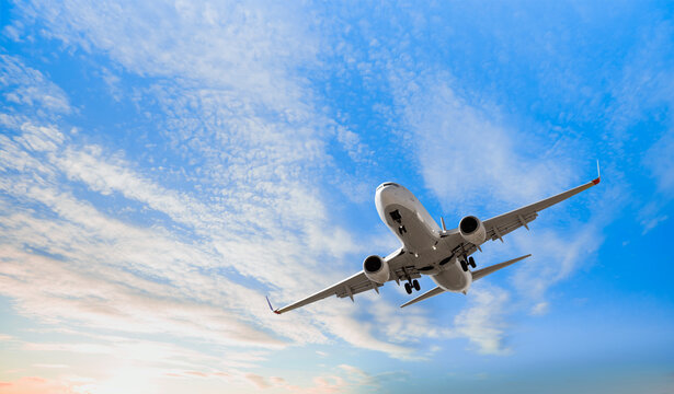 White passenger airplane flying in the sky amazing clouds in the background - Travel by air transport