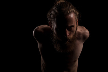 Fototapeta premium Portrait of cool tattooed bearded hipster guy on black background in studio photo. Expression and fashion