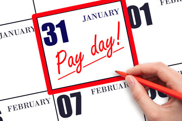 Hand writing text PAY DATE on calendar date January 31 and underline it. Payment due date