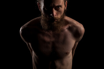 Fototapeta premium Portrait of cool tattooed bearded hipster guy on black background in studio photo. Expression and fashion