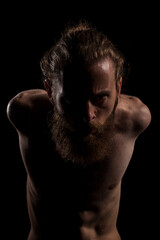 Portrait of cool tattooed bearded hipster guy on black background in studio photo. Expression and fashion