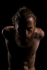 Fototapeta premium Portrait of cool tattooed bearded hipster guy on black background in studio photo. Expression and fashion