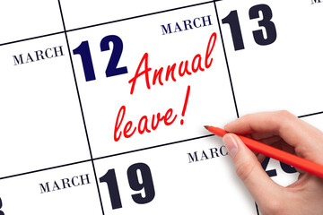 Hand writing the text ANNUAL LEAVE and drawing the sun on the calendar date March 12