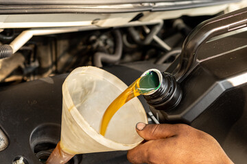 Pouring new engine oil into the vehicle engine