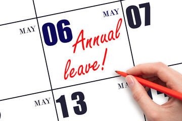 Hand writing the text ANNUAL LEAVE and drawing the sun on the calendar date May 6