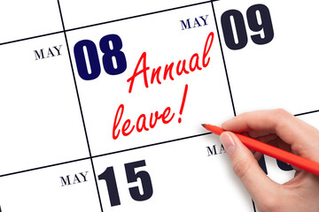Hand writing the text ANNUAL LEAVE and drawing the sun on the calendar date May 8