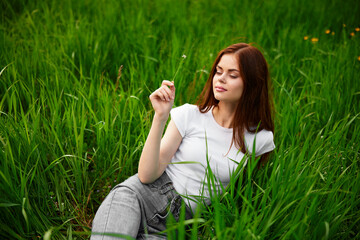 woman in gray jeans resting lying in the grass
