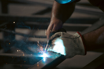 Industry worker welding iron pieces at work