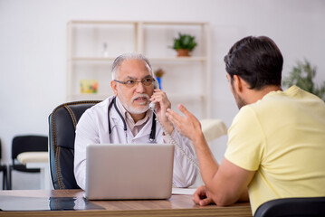 Young male patient visiting old male doctor