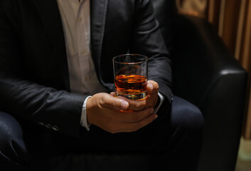 Closeup businessmen holding a glass of whiskey