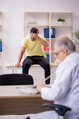Fototapeta premium Young male patient visiting old male doctor