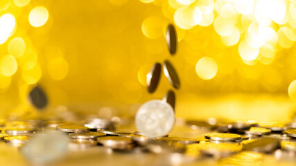 Golden coins falling on shiny background