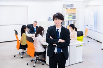 笑顔で腕を組む若いビジネスマン