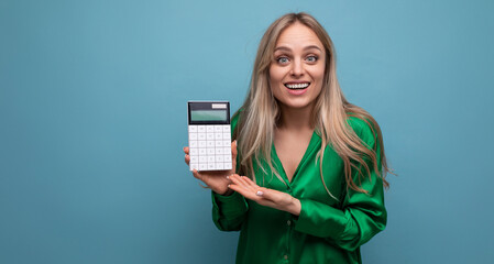european pleasantly perplexed stylish blonde girl with a calculator on a blue background