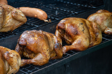 Smoking chicken and sausages in a smoker in Kaziuko Muge or Saint Casimir's Fair, a spring annual folk arts and crafts fair in Vilnius, Lithuania, Europe