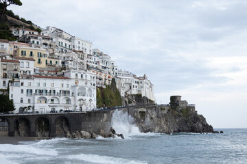 Amalfi coast in Italy with strong waves and overcast sky