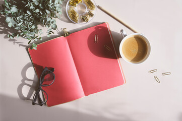 aesthetic minimalist workspace in trendy 2023 colors. Home office, blog and social media concept. Flat lay of note book, coffee and glasses in morning sun