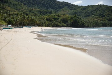 Dreamlike idyllic beach of El Nideo, Palawan in the Philippines with palm trees along the beach.