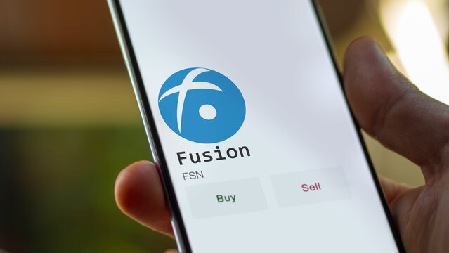March 11 2023 London UK. An investor's analyzing the Fusion  coin on screen. A phone shows the ETF's prices to invest in FSN