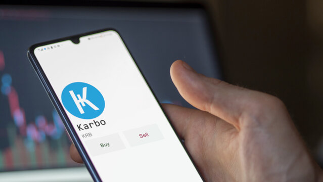March 11 2023 London UK. An investor's analyzing the Karbo  coin on screen. A phone shows the ETF's prices to invest in KRB