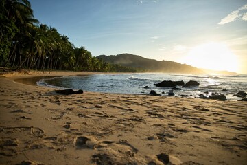 Young  sunset on the beach of El Nido, Palawan in the Philippines, hills on the horizon, beach in the foreground.