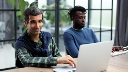 Managers with laptop sitting in modern office