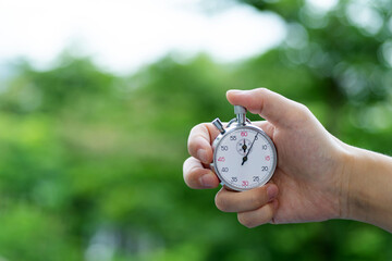 People hand holding stopwatch outdoors