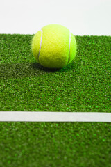 Sport Ideas. One Separate Tennis ball on green artificial grass surface.